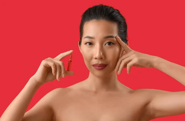 Vacker Asiatisk Kvinna Med Ampull Röd Bakgrund Hudvårds Koncept — Stockfoto
