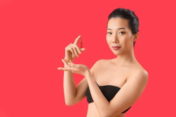 Mooie Aziatische Vrouw Met Ampul Rode Achtergrond Huidverzorgingsconcept — Stockfoto
