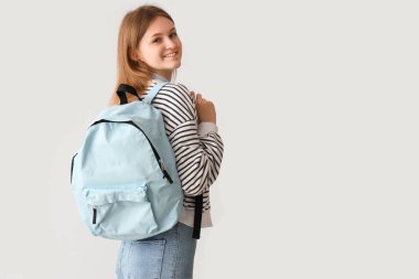 Gri arka plan üzerinde sırt çantası ile kız öğrenci