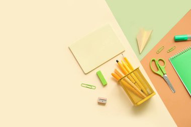 Renk arkaplanı üzerine not defterleri ve farklı okul sayfaları içeren kompozisyon