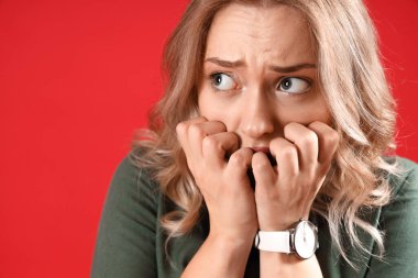 Kırmızı arka planda panik atak geçiren genç bir kadın.