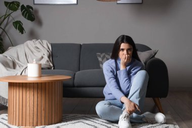 Evde panik atak geçiren genç bir kadın.