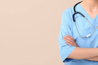 Bej arka planda steteskobu olan kadın doktor.