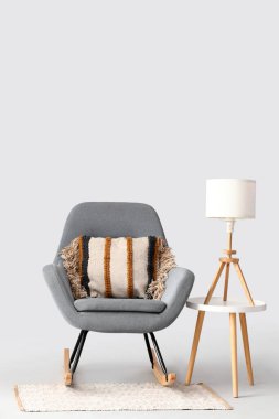 Sallanan sandalye ve beyaz arka planda halı.