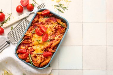 Beyaz fayanslı domates soslu ve peynirli makarna kabı.