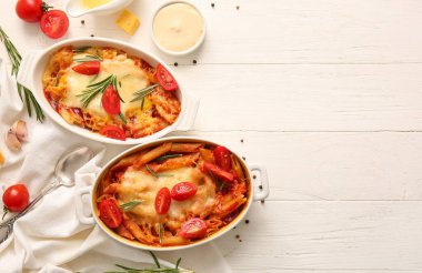 Beyaz fayanslı domates soslu ve peynirli makarna tabakları.