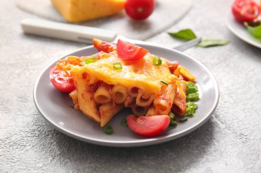 Gri arkaplanda domates soslu ve peynirli makarna.