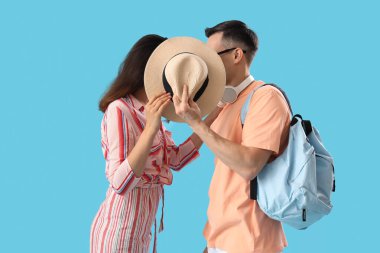 Mavi arka planda yaz şapkalı genç çift