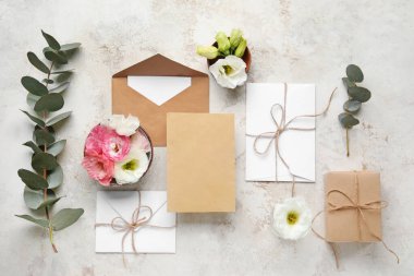 Zarflı kompozisyon, boş kartlar ve bej arka planda östoma çiçekleri. Düğün davetiyesi konsepti