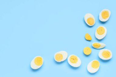 Mavi arka planda dilimlenmiş lezzetli haşlanmış yumurtalar.