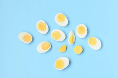 Mavi arka planda dilimlenmiş lezzetli haşlanmış yumurtalar.