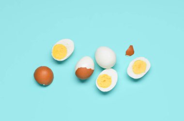 Lezzetli kaynamış yumurta ve mavi arka planda kabuklar.