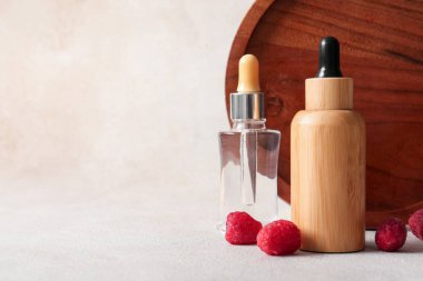 Beyaz arka planda kozmetik ahududu yağı şişeleri