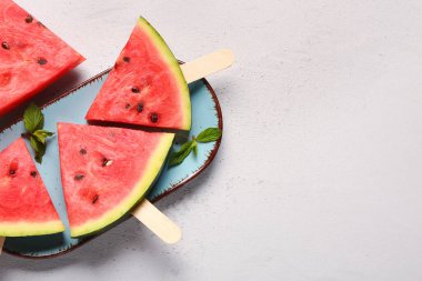 Tatlı karpuz çubukları ve beyaz arka planda nane şekeri.