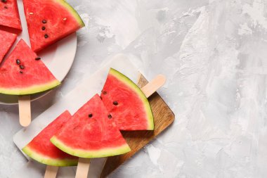 Arkaplanda tatlı karpuz çubukları olan tabak ve yemek.