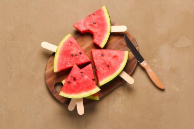 Kahverengi arka planda tatlı karpuz çubukları olan ahşap tahta.