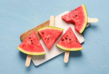 Mavi arka planda tatlı karpuz çubukları olan tahta