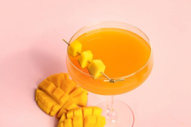 Pembe arka planda bir bardak taze mango suyu