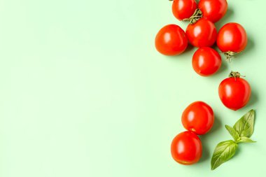 Yeşil arka planda taze vişneli domates ve fesleğen.