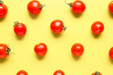 Sarı arka planda bir sürü taze vişneli domates.