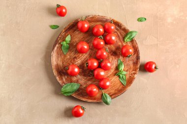 Taze kiraz domatesli ahşap masa ve kahverengi masada fesleğen.