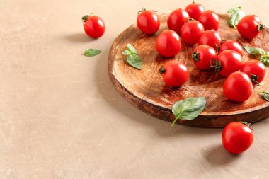 Taze kiraz domatesli ahşap masa ve kahverengi masada fesleğen.