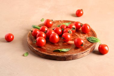 Taze kiraz domatesli ahşap masa ve kahverengi masada fesleğen.