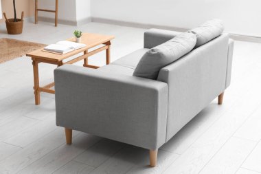 Modern oturma odası içi rahat gri kanepe ve masa ile dolu.