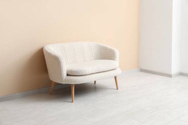 Bej duvarın yanındaki rahat beyaz kanepe.