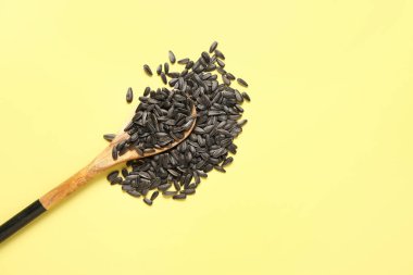 Sarı arka planda ayçiçeği tohumlu kaşık
