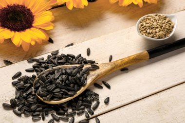 Hafif ahşap arka planda ayçiçeği tohumlu kaşık