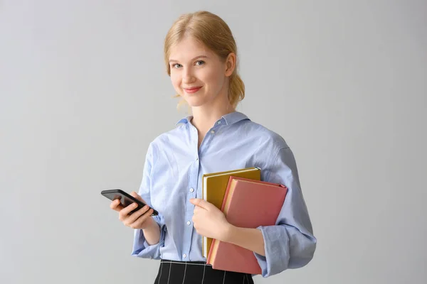 Female Student Books Using Mobile Phone Grey Background — Stock Photo, Image