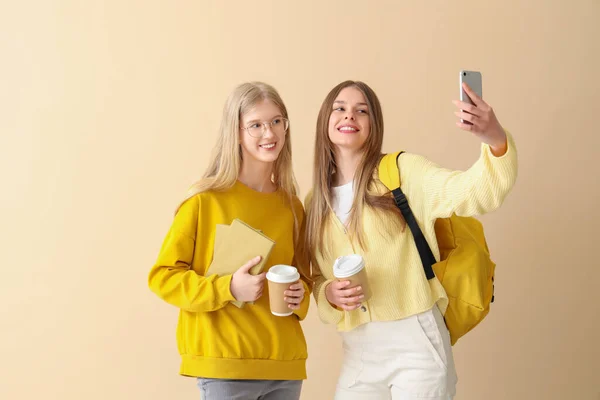 Happy Female Students Books Cups Coffee Taking Selfie Pale Yellow — Stock Photo, Image