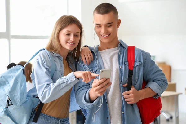 Estudiantes Felices Con Mochilas Usando Teléfono Móvil Aula — Foto de Stock