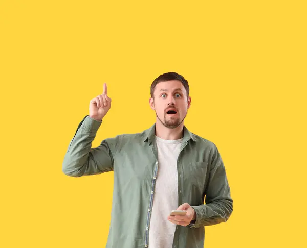 Man Smartphone Raised Index Finger Yellow Background — Stock Photo, Image