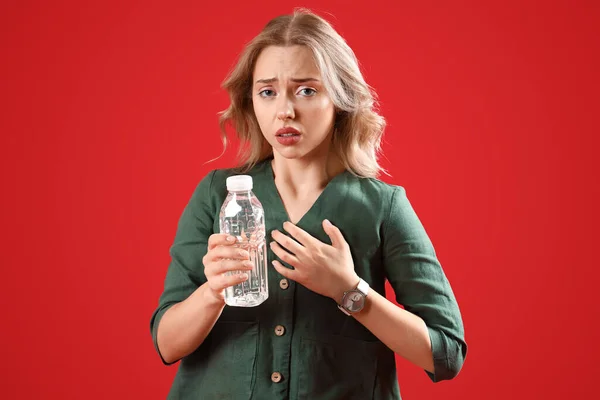 Νεαρή Γυναίκα Μπουκάλι Νερό Που Παθαίνει Κρίση Πανικού Κόκκινο Φόντο — Φωτογραφία Αρχείου