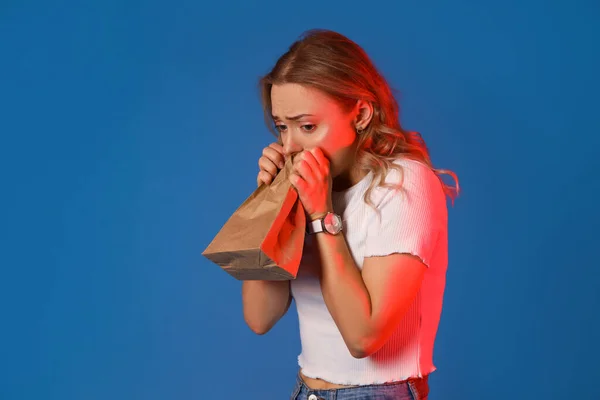 Young Woman Paper Bag Having Panic Attack Blue Background — Stock Photo, Image