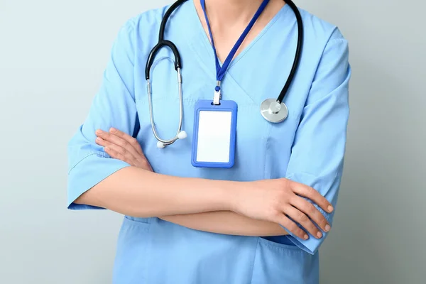 Kobieta Lekarz Stetoskopem Odznaką Szarym Tle — Zdjęcie stockowe