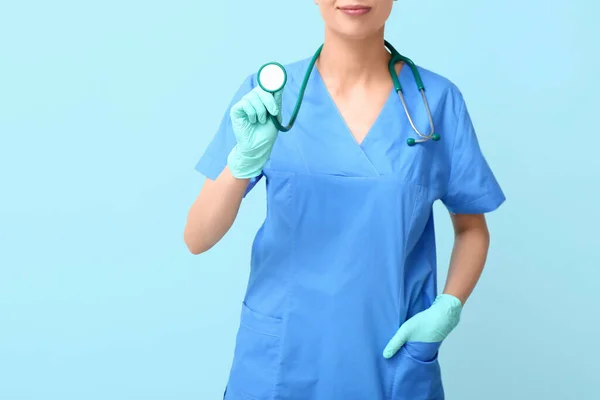 带听诊器和蓝色背景医用手套的女医生 — 图库照片