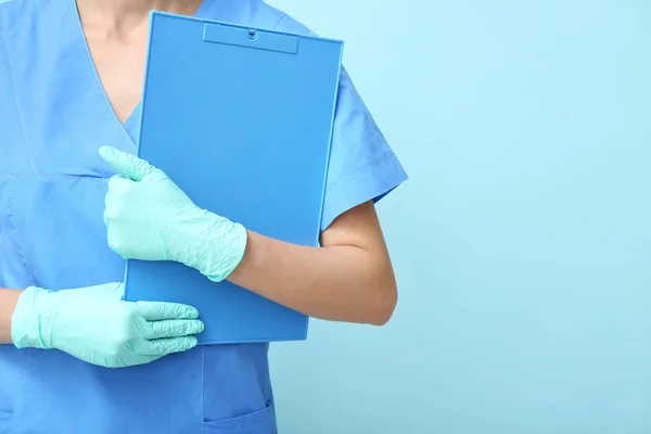 Kvinna Läkare Medicinska Handskar Som Håller Urklipp Blå Bakgrund — Stockfoto