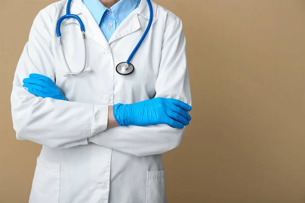 Ärztin Mit Stethoskop Und Medizinhandschuhen Auf Beigem Hintergrund — Stockfoto