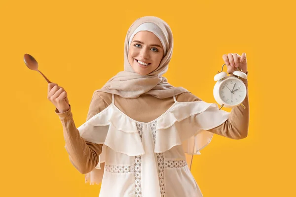 Muslimská Žena Lžící Budíkem Žlutém Pozadí — Stock fotografie