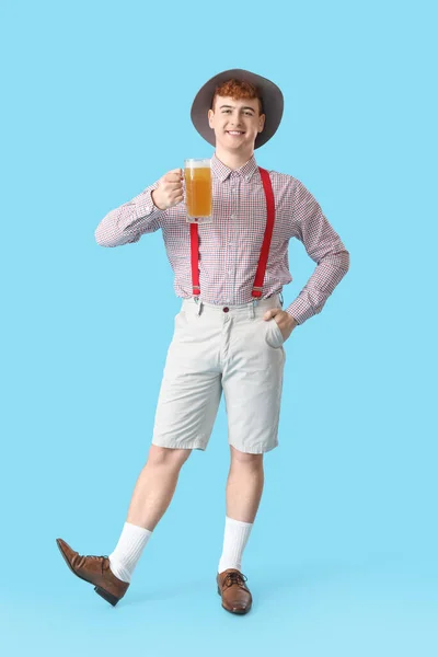 Młody Człowiek Tradycyjnych Niemieckich Ubraniach Piwem Niebieskim Tle — Zdjęcie stockowe