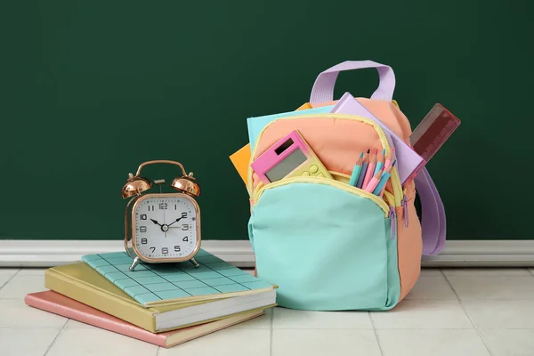 Bunter Schulrucksack Mit Notizbüchern Wecker Und Taschenrechner Auf Weißem Fliesentisch — Stockfoto