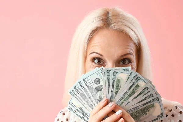 ピンクの背景にドル紙幣を持つ熟女 クローズアップ — ストック写真