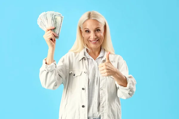 Mavi Arka Planda Dolar Banknotları Olan Olgun Bir Kadın — Stok fotoğraf