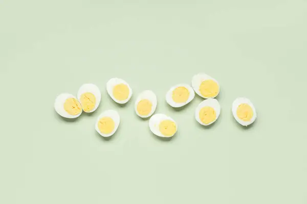 Helften Van Smakelijke Gekookte Eieren Groene Achtergrond — Stockfoto