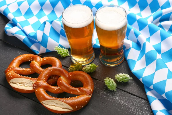 stock image Flag of Bavaria, mugs with beer and pretzels on black wooden background