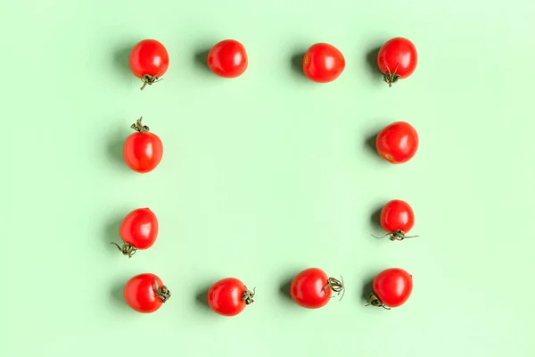 stock image Frame made of fresh cherry tomatoes on green background