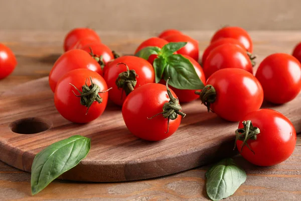 Deska Świeżymi Pomidorami Wiśniowymi Bazylią Drewnianym Stole Zbliżenie — Zdjęcie stockowe